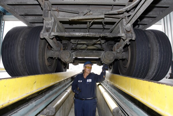 California Highway Patrol commercial vehicle inspector Ruben Montanez inspects the undercarriage of a truck entering the U.S. from Mexico at the CHP's Otay Mesa Inspection Station Thursday, Sept. 6, 2007, in San Diego. (AP Photo/Denis Poroy)